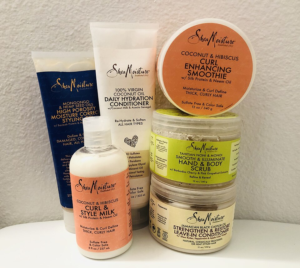 SheaMoisture-producten, met rechtsboven een oranje Curl Enhancing Smoothie-pot waarop Silk Protein staat.