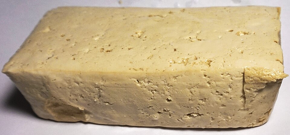 Een blok naturel tofu op een lichte ondergrond